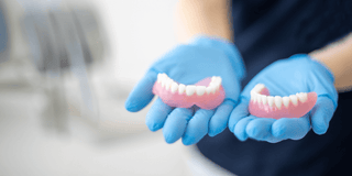 Dentist holding dentures