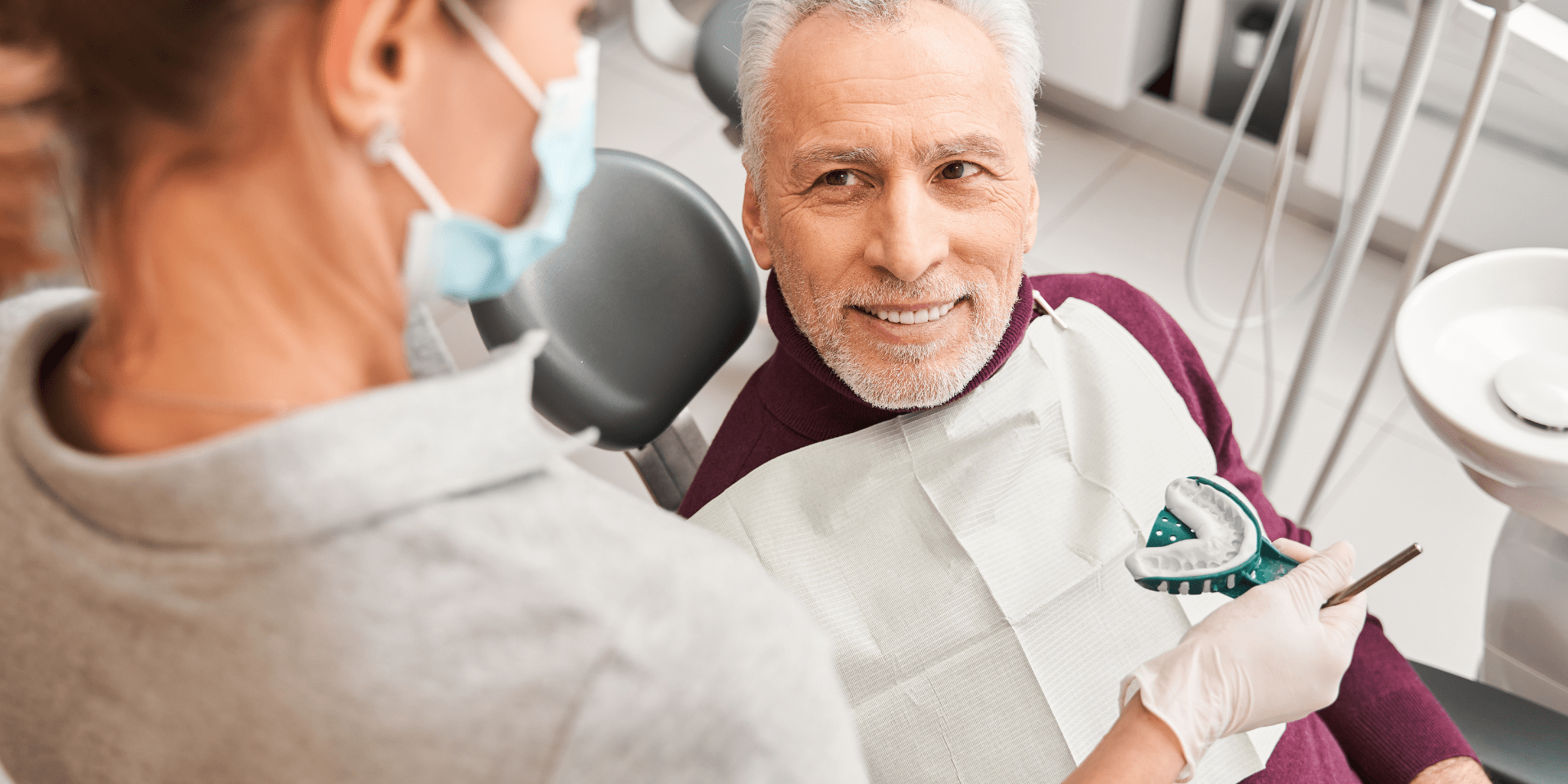 Patient discussing dental treatment while dentist holds an impression tray