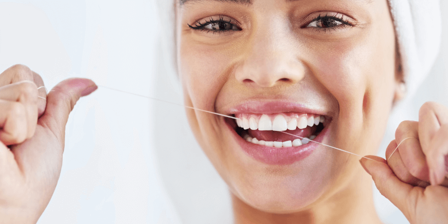 Person smiling while flossing their teeth
