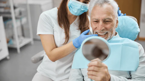 Patient smiling while viewing dental implant results at Envy Dental